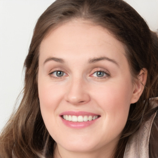 Joyful white young-adult female with long  brown hair and grey eyes