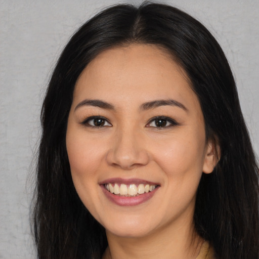 Joyful asian young-adult female with long  brown hair and brown eyes