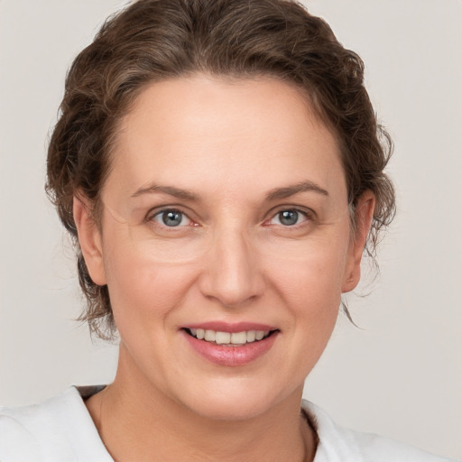 Joyful white adult female with medium  brown hair and grey eyes