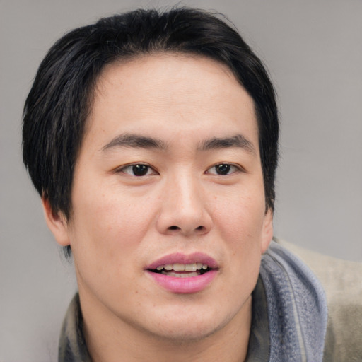 Joyful asian young-adult male with short  black hair and brown eyes