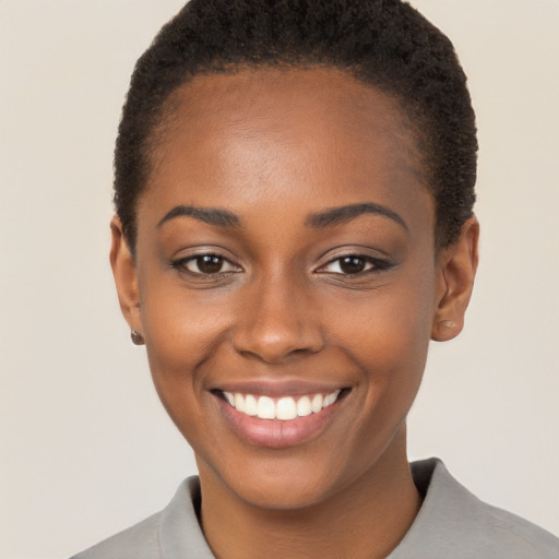 Joyful black young-adult female with short  brown hair and brown eyes