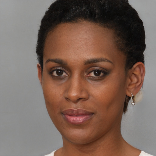 Joyful black young-adult female with short  brown hair and brown eyes