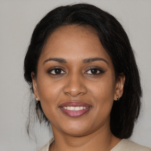 Joyful black young-adult female with medium  black hair and brown eyes