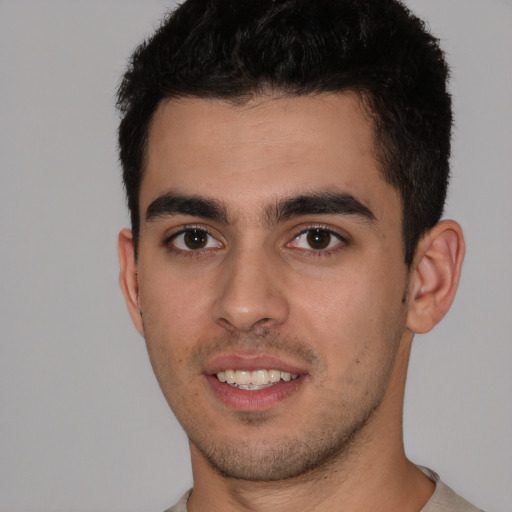 Joyful white young-adult male with short  black hair and brown eyes