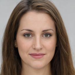 Joyful white young-adult female with long  brown hair and green eyes