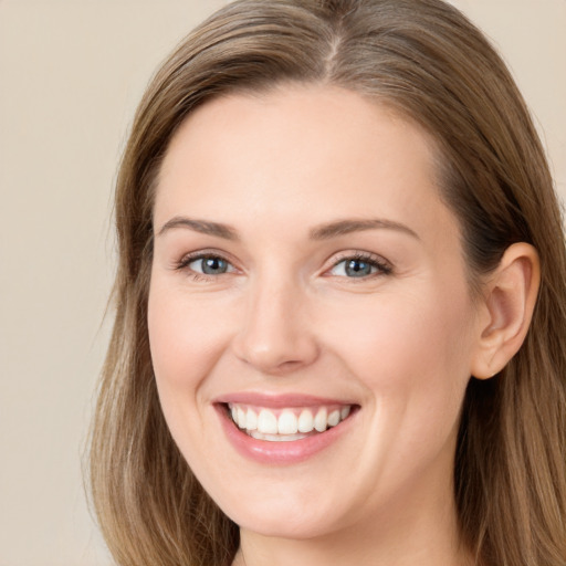 Joyful white young-adult female with long  brown hair and grey eyes