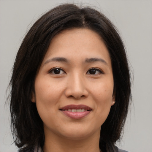 Joyful asian young-adult female with medium  brown hair and brown eyes