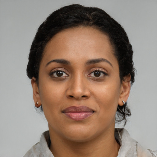 Joyful black young-adult female with short  black hair and brown eyes