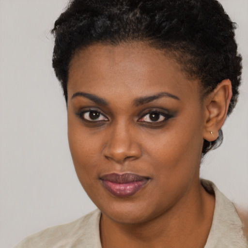 Joyful black young-adult female with short  brown hair and brown eyes