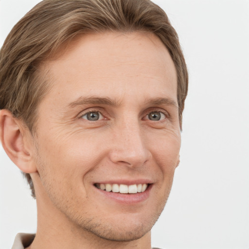 Joyful white young-adult male with short  brown hair and grey eyes