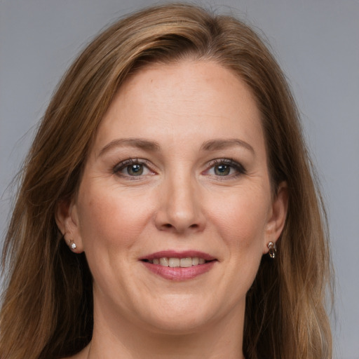 Joyful white adult female with long  brown hair and grey eyes