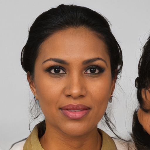 Joyful black young-adult female with medium  black hair and brown eyes
