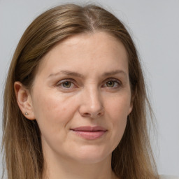 Joyful white adult female with long  brown hair and grey eyes