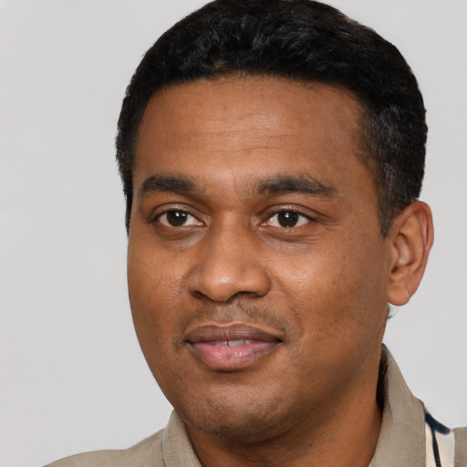 Joyful black young-adult male with short  black hair and brown eyes