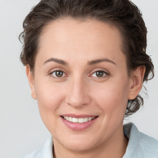 Joyful white young-adult female with medium  brown hair and grey eyes