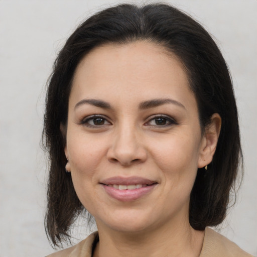 Joyful latino young-adult female with medium  brown hair and brown eyes