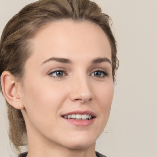 Joyful white young-adult female with medium  brown hair and grey eyes