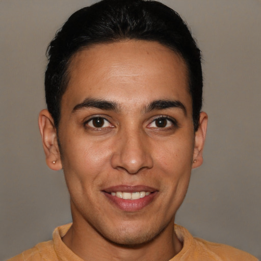 Joyful latino young-adult male with short  brown hair and brown eyes