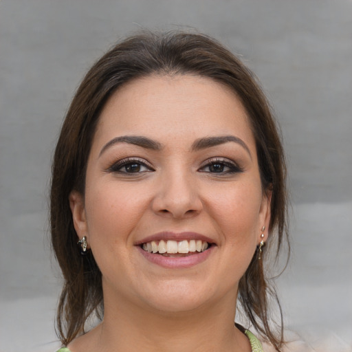 Joyful white young-adult female with medium  brown hair and brown eyes