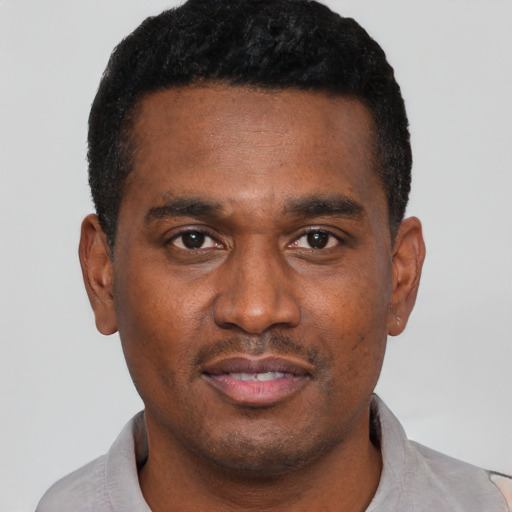 Joyful black young-adult male with short  black hair and brown eyes