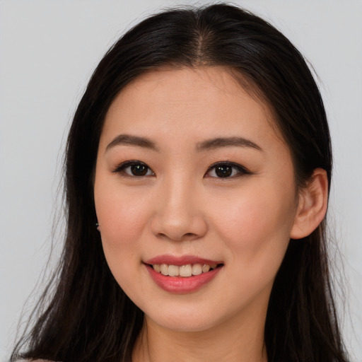 Joyful asian young-adult female with long  brown hair and brown eyes