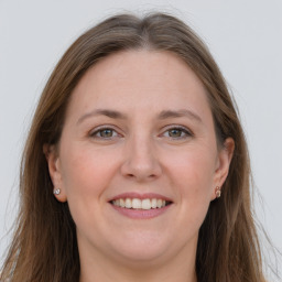 Joyful white adult female with long  brown hair and grey eyes