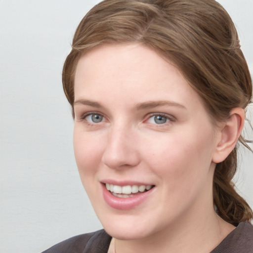 Joyful white young-adult female with medium  brown hair and blue eyes