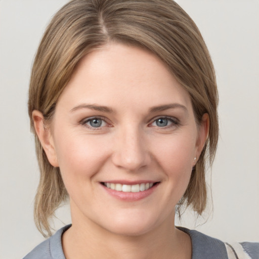 Joyful white young-adult female with medium  brown hair and grey eyes