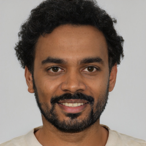 Joyful black young-adult male with short  black hair and brown eyes