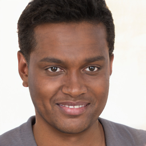 Joyful black young-adult male with short  brown hair and brown eyes