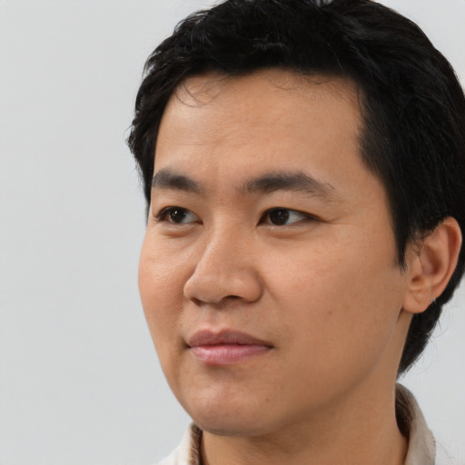 Joyful asian young-adult male with short  black hair and brown eyes