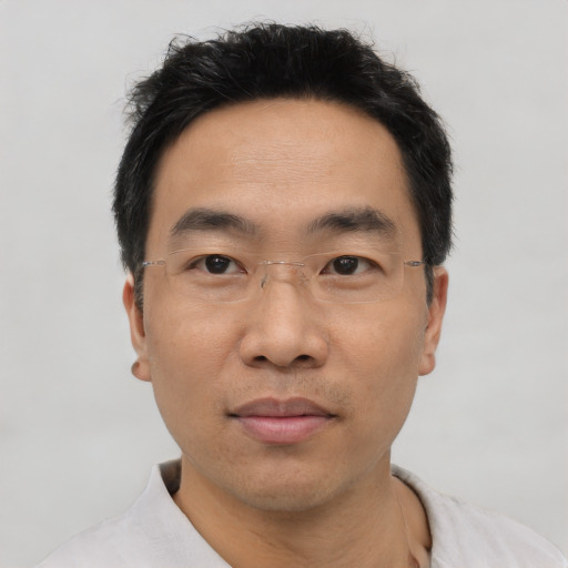 Joyful asian adult male with short  black hair and brown eyes