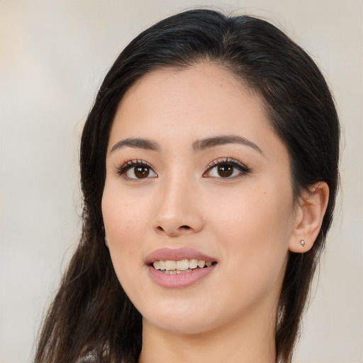 Joyful asian young-adult female with long  brown hair and brown eyes