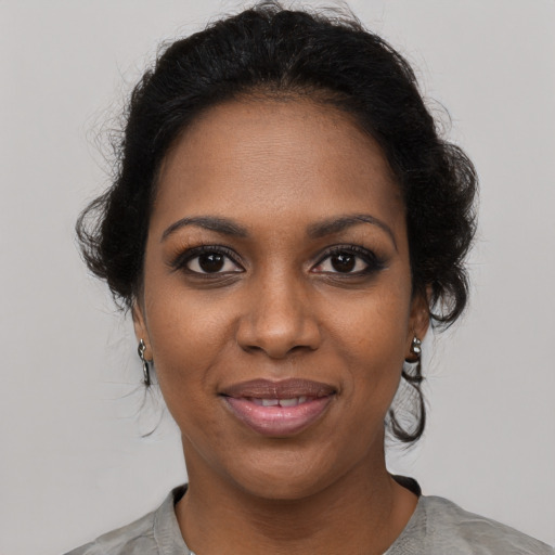 Joyful black young-adult female with medium  black hair and brown eyes