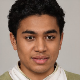 Joyful latino young-adult male with short  brown hair and brown eyes