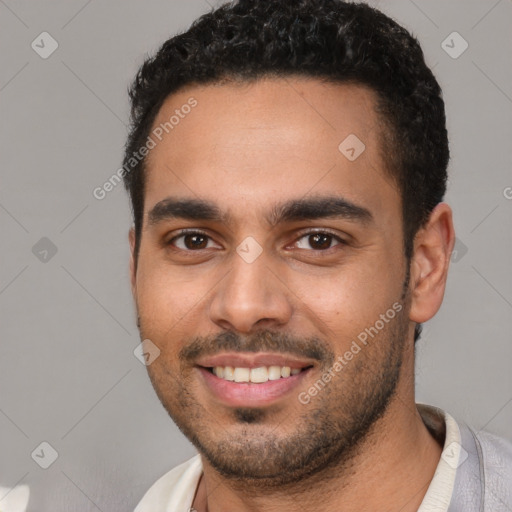 Joyful latino young-adult male with short  black hair and brown eyes