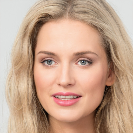 Joyful white young-adult female with long  brown hair and blue eyes