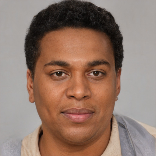 Joyful black adult male with short  brown hair and brown eyes