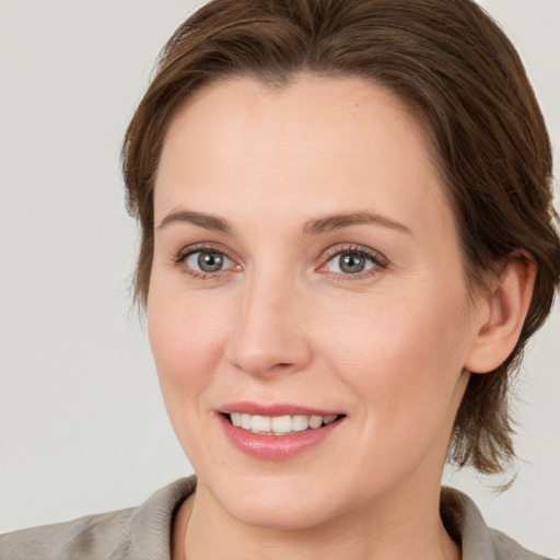 Joyful white adult female with medium  brown hair and grey eyes