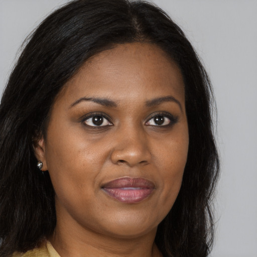 Joyful black young-adult female with long  brown hair and brown eyes