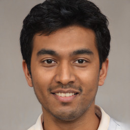 Joyful latino young-adult male with short  black hair and brown eyes