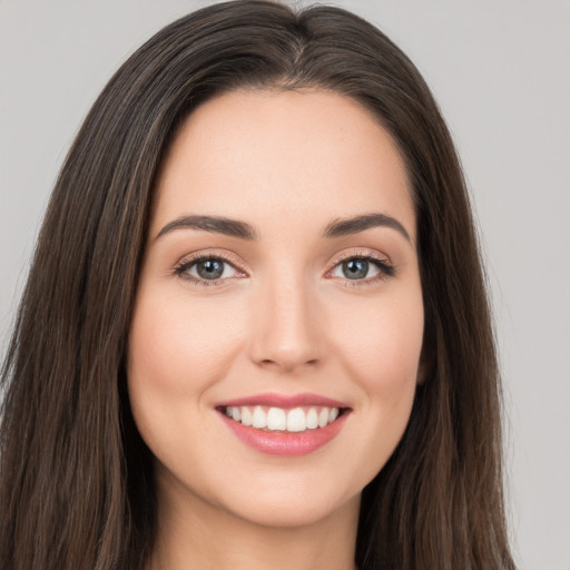 Joyful white young-adult female with long  brown hair and brown eyes