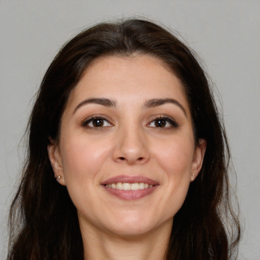 Joyful white young-adult female with long  brown hair and brown eyes