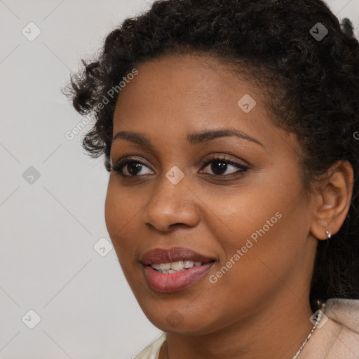 Joyful black young-adult female with long  brown hair and brown eyes