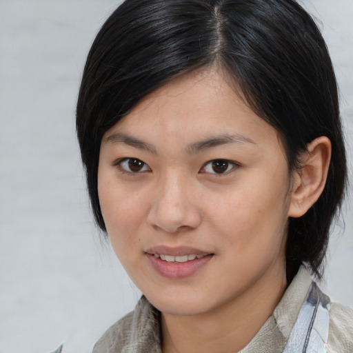 Joyful asian young-adult female with medium  brown hair and brown eyes