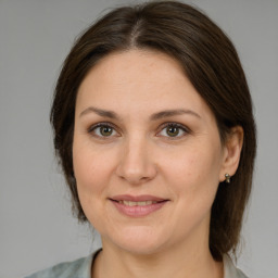 Joyful white adult female with medium  brown hair and grey eyes