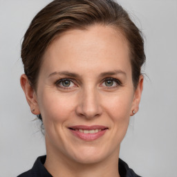 Joyful white adult female with medium  brown hair and grey eyes