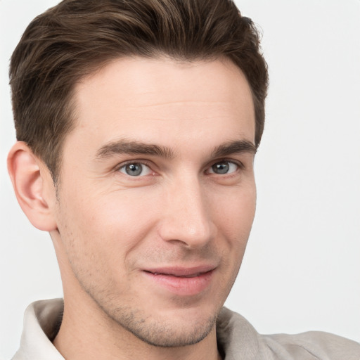 Joyful white young-adult male with short  brown hair and grey eyes