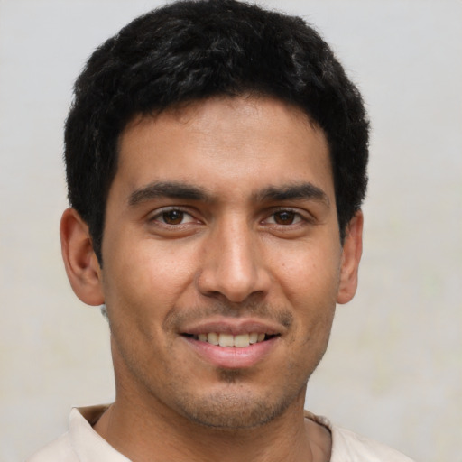 Joyful latino young-adult male with short  brown hair and brown eyes