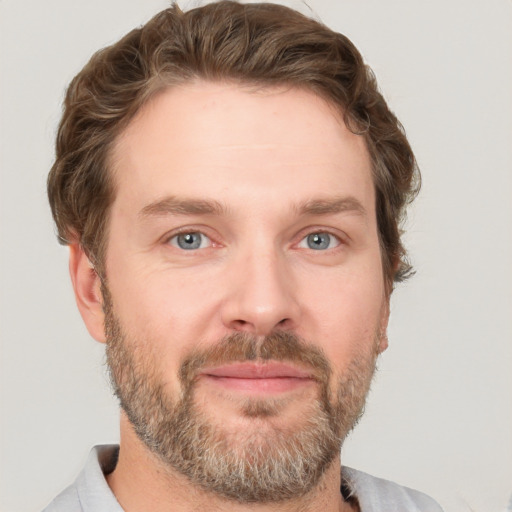 Joyful white adult male with short  brown hair and grey eyes